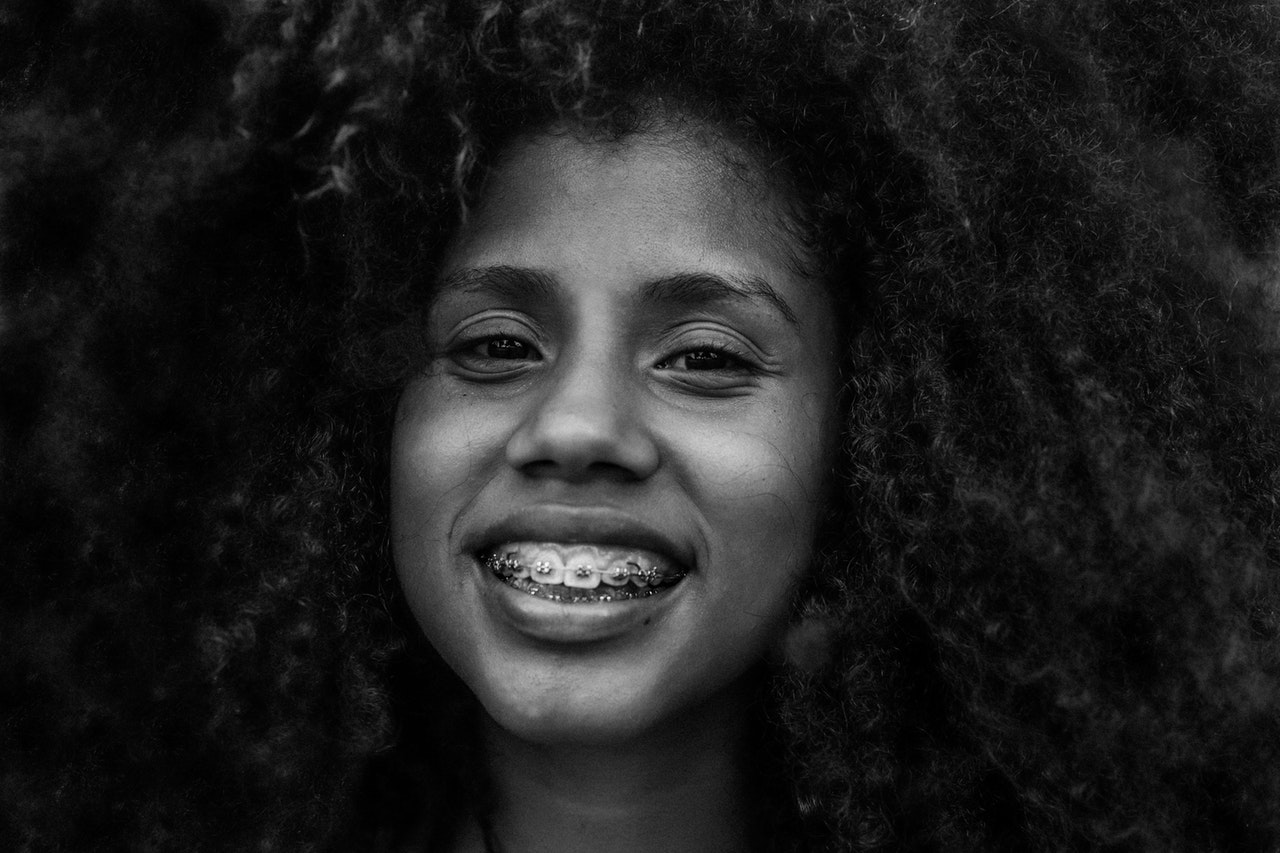 Smiling woman with dental braces in black and white