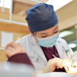 woman doing dental care on girl lying in a dental chair