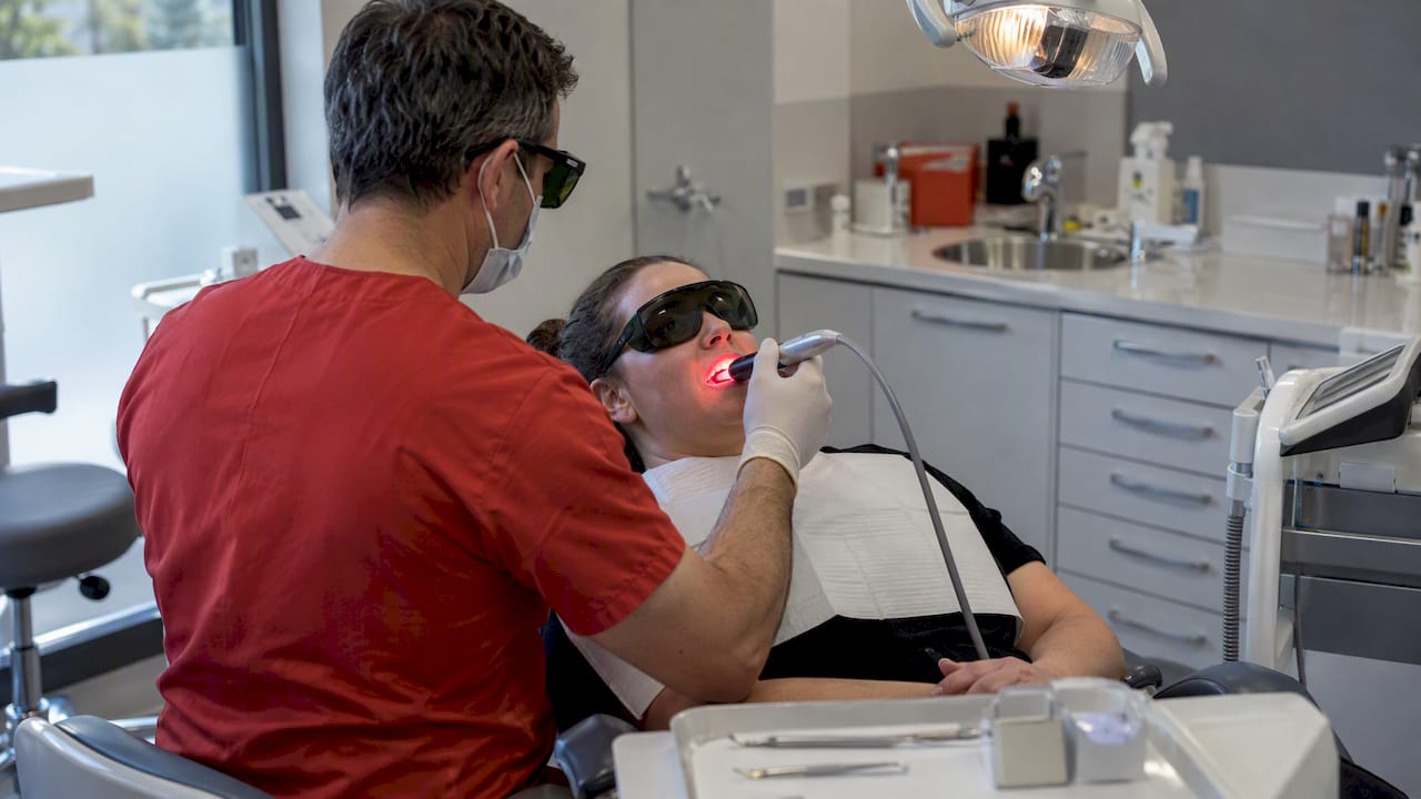 Clinician using laser therapy for tooth sensitivity