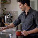 Coffee drinker reaching for water at home